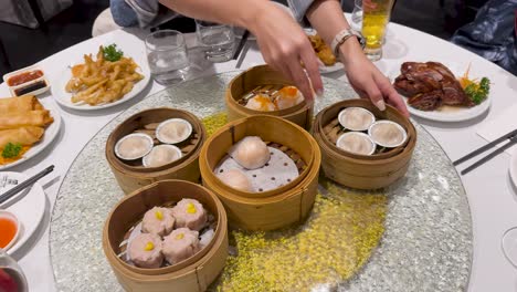 a vibrant table setting with various dim sum dishes in bamboo steamers, accompanied by sauces and side dishes