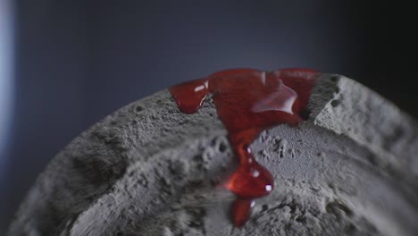 red-wax-dripping-on-grey-concrete-close-up