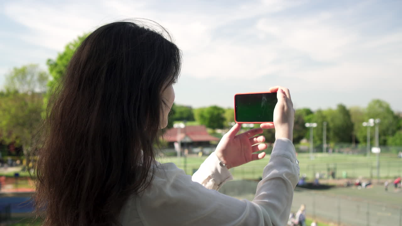 bonita mujer italiana turista tomando fotografías de un parque en wimbledon londres