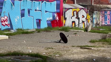 graffiti azul en una pared de ladrillo con una antena parabólica dañada en primer plano - distópica apocalíptica