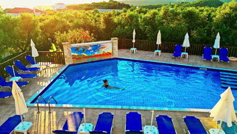 attractive woman in a swimming pool at sunset in greece