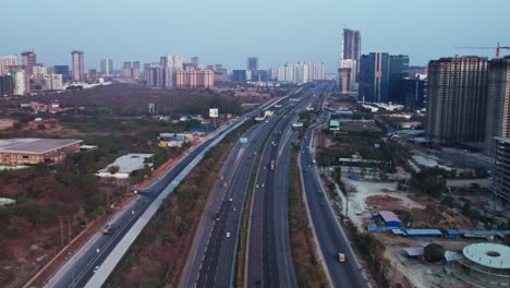 nehru outer ring road with vehicles and under construction buildings at financial district, nanakramguda, hyderabad, telangana, india. day time, moving up, drone shot, 4k.