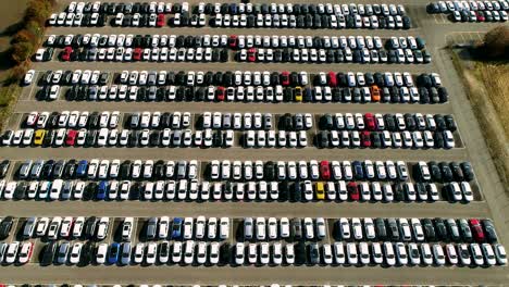 aerial footage of finished cars ready to be shipped on huge distribution center