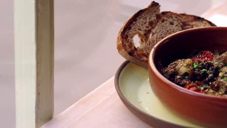 Cod-and-chorizo-bake-with-sourdough-bread-by-window,-pan