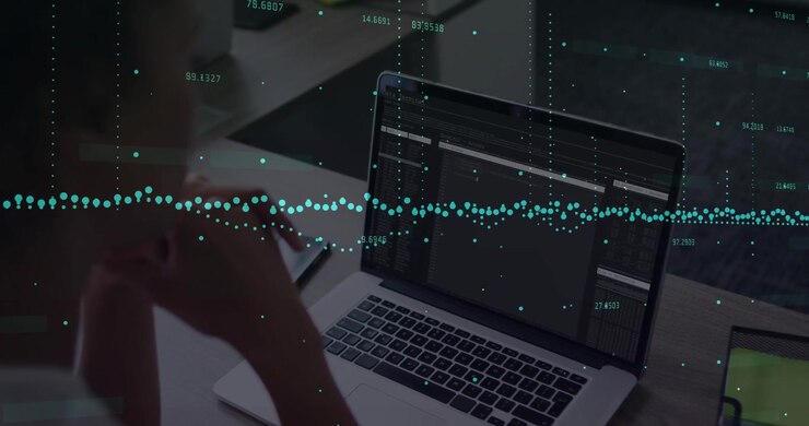 Woman leaning over laptop, tapping trackpad and updating teal waveform for data analytics notes