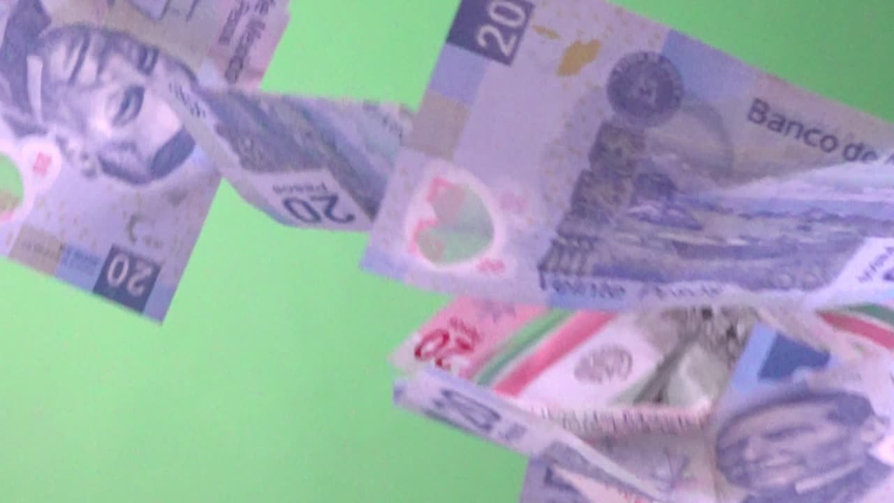 disparo en cámara lenta de billetes de banco mexicanos cayendo contra una pantalla verde