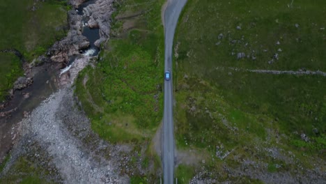 el coche conduce por una carretera rural remota en una zona montañosa