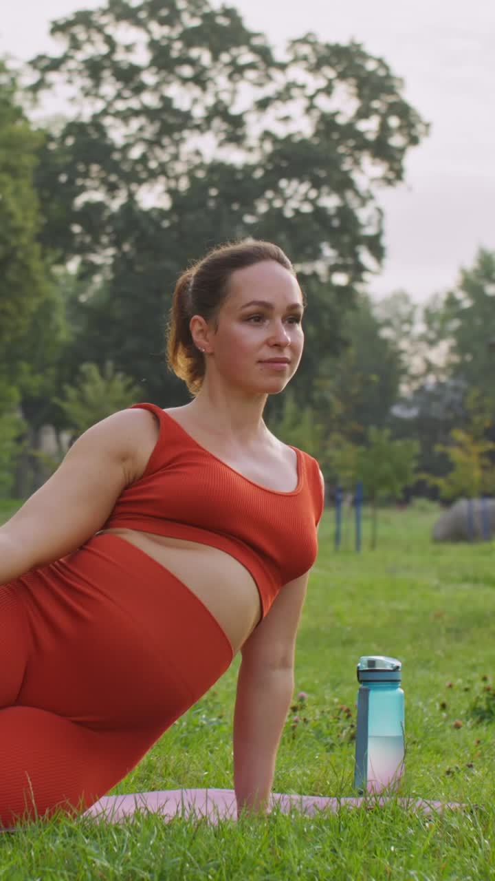 беременная женщина занимается йогой в парке