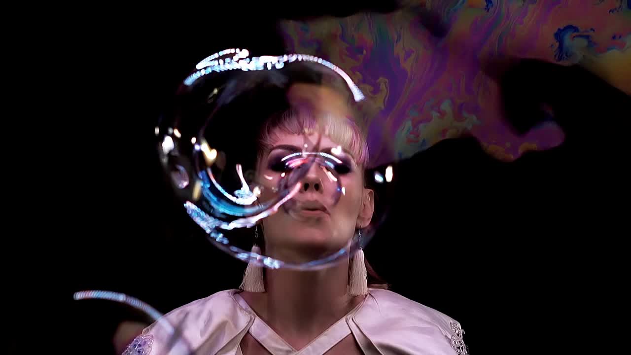 cu trucos en cámara lenta con pompas de jabón una niña soplando una burbuja hacia la cámara