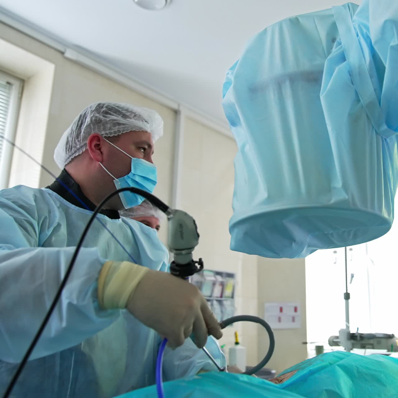 Surgery specialist applies technological device with micro camera. Doctor watches the inner organ at the screen