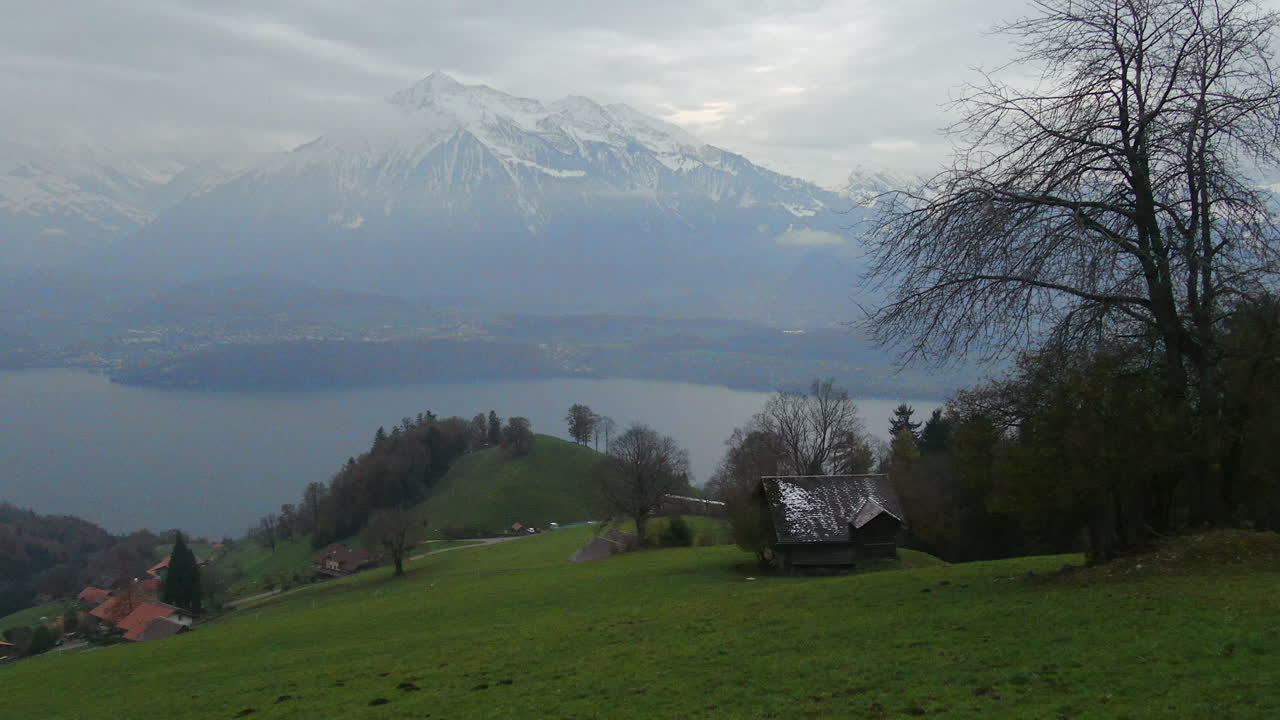 Cinematic aerial drone beautiful Swiss Alps Pyramid Peak countryside dancing in the fog hillside sounds of music scene Thun Bern Interlocken Switzerland mountainside down jib movement