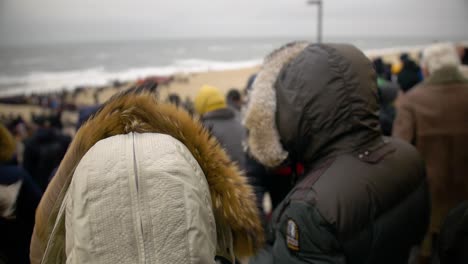 people standing on a windy beach at westerland, sylt, germany