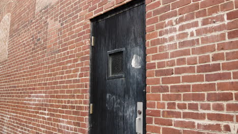 black wooden door in brick alley - closeup