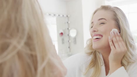 una mujer blanca feliz de talla grande delante del espejo haciendo maquillaje en cámara lenta.