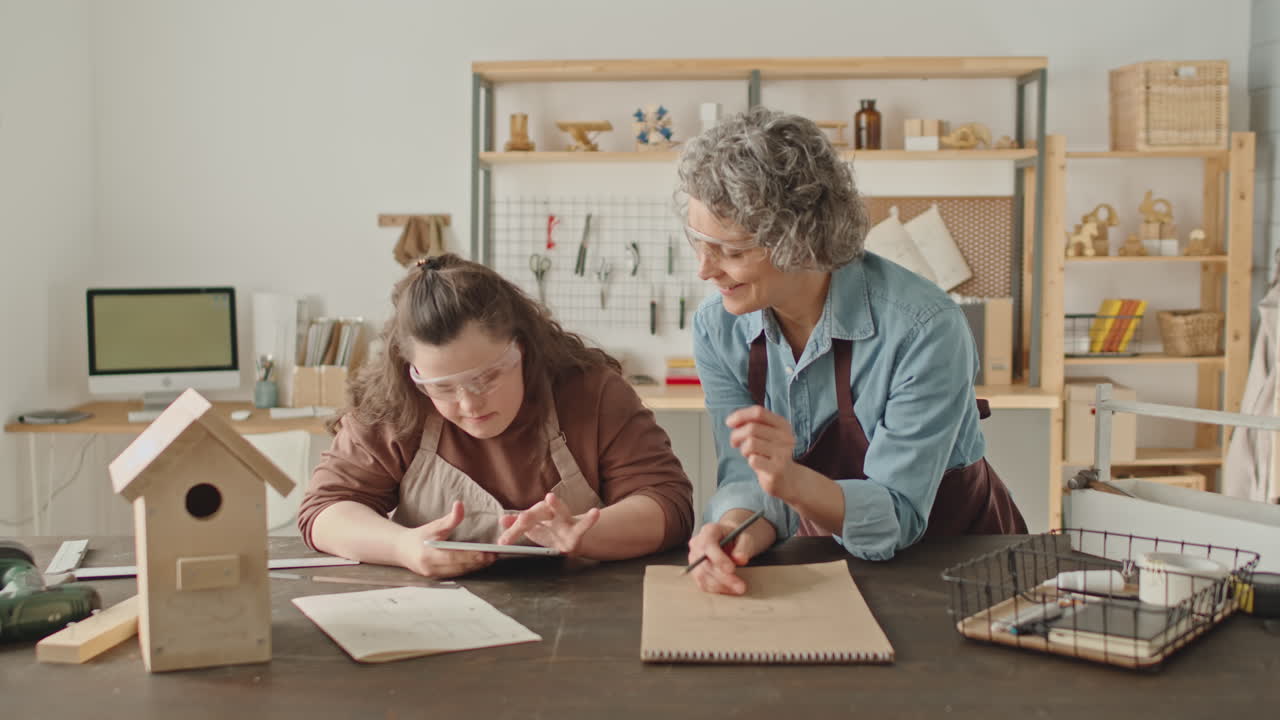 Woman teaching a girl to design a birdhouse