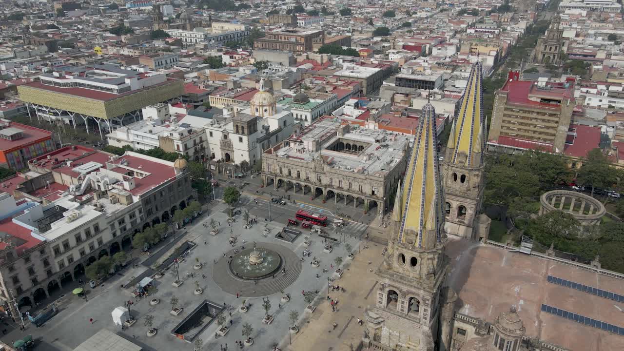 Drone subindo em frente à praça histórica de Guadalajara com a cidade ao fundo, Igreja Católica no México.