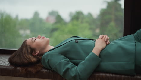 fatigued professional reclines on windowsill. woman feels depleted from relentless expectations of corporate environment with energy sapped