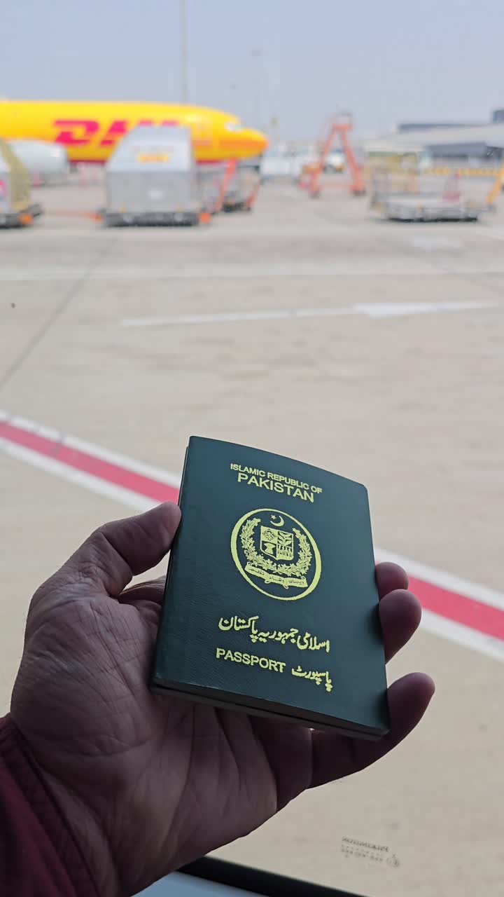 Pakistani Passport at the Airport with a DHL Plane in the Background