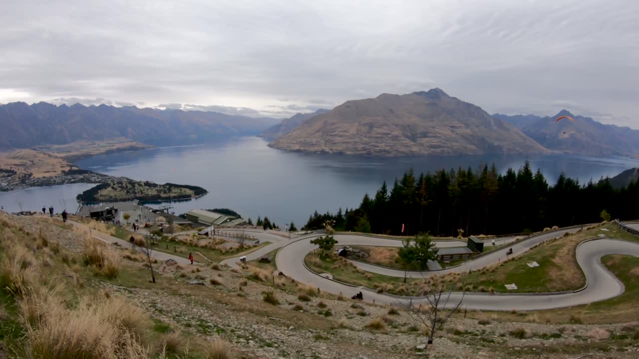 Pista da slittino che scende lungo il fianco della montagna a Queenstown, Nuova Zelanda, con vista sul lago Wakatipu