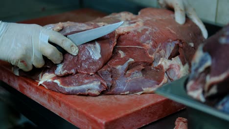 el chef corta carne cruda con un cuchillo.