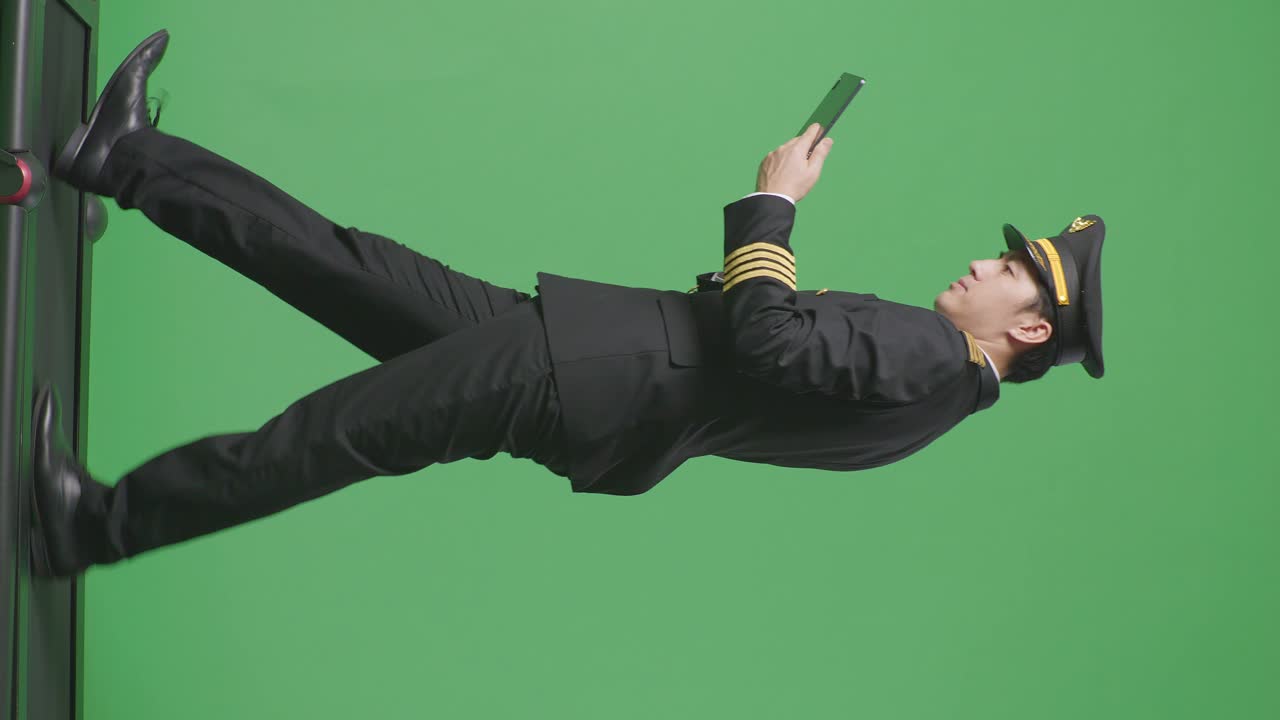 녹색 화면에서 태블릿을 사용하는 조종사