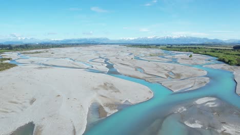 flying high upstream above main channel in braided waimakariri river in new zealand - beautiful turquoise water, wide-open spaces and high horizon