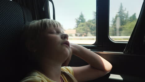 the girl is sleeping by the window in the back seat of the car a tedious journey with a child