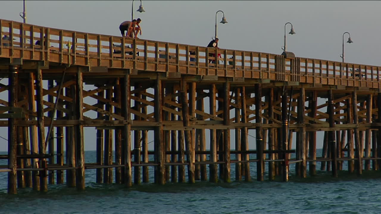 젊은이들이 부두에서 바다로 뛰어든다