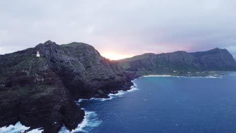 Una-Impresionante-Vista-Aérea-Del-Faro-De-Makapu&#39;u-Point-Al-Atardecer,-Que-Muestra-Los-Espectaculares-Acantilados-Y-Las-Serenas-Aguas-Turquesas-De-La-Costa-De-Oahu.