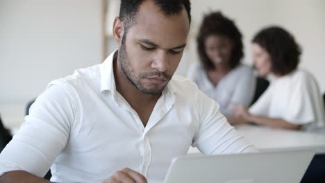 Vista-De-Cerca-De-Un-Hombre-Barbudo-Serio-Que-Trabaja-Con-Una-Computadora-Portátil