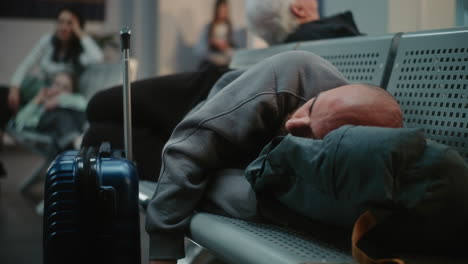 tired traveler sleeping in airport lounge