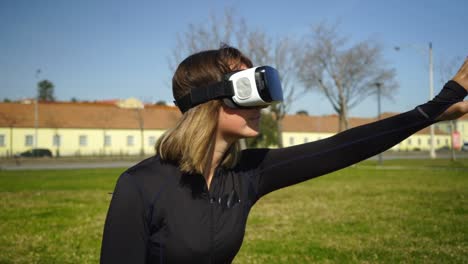 Sporty-girl-in-virtual-reality-headset-sitting-on-grass