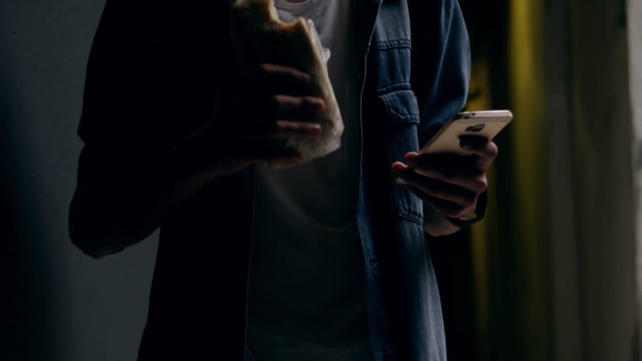 hombre usando teléfono móvil mientras come 4k