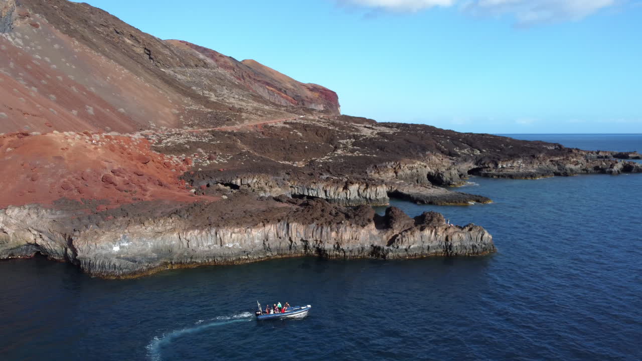 bahía de cala tacoron, que es recorrida por una lancha rápida con un grupo de personas alrededor de la costa rocosa en un mar tranquilo en un día soleado, el hierro - toma aérea