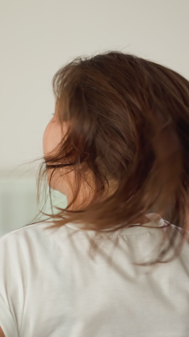 달리기 여성은 집에서 머리카락을 어내고,  티셔츠를 입은 스포츠 여성은 국내 체육관에서 느슨한 머리카락과 함께 조하고, 복지를 위해 운동합니다.