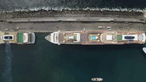 top down cinematic pan left of aerial view of cruise ships docked in port in the city of ponta delgada, azores