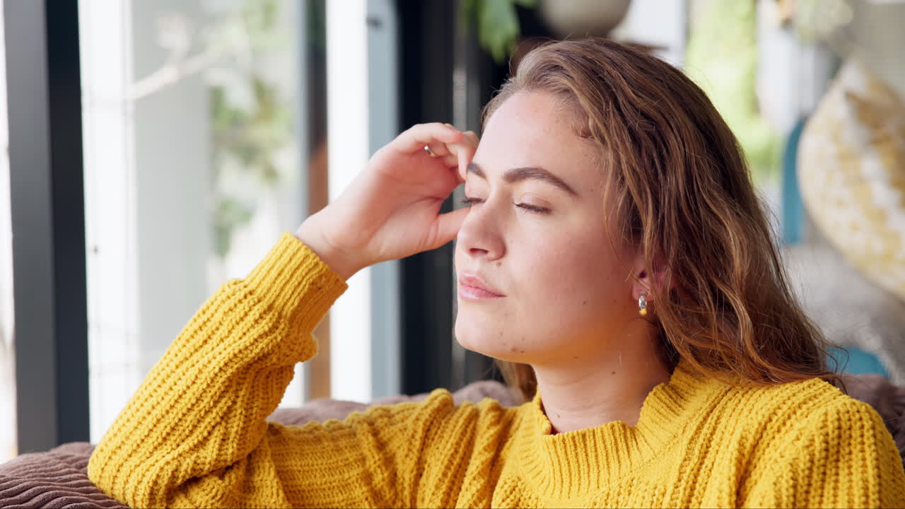 Woman in yellow sweater daydreaming indoors