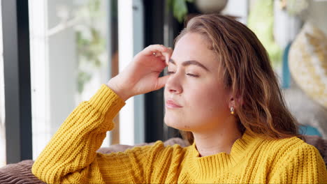woman in yellow sweater daydreaming indoors