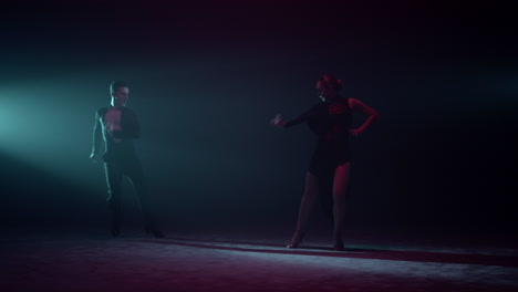 Hermosos-Bailarines-Levantando-La-Mano-En-El-Escenario.-Hombre-Y-Mujer-Bailando-En-Un-Salón-Oscuro.