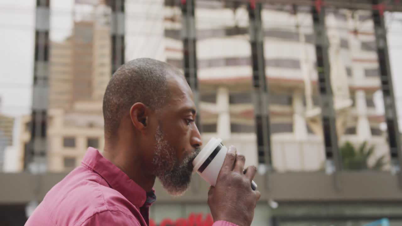 African American man drinking a coffee and using his phone