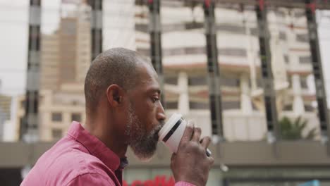 african american man drinking a coffee and using his phone