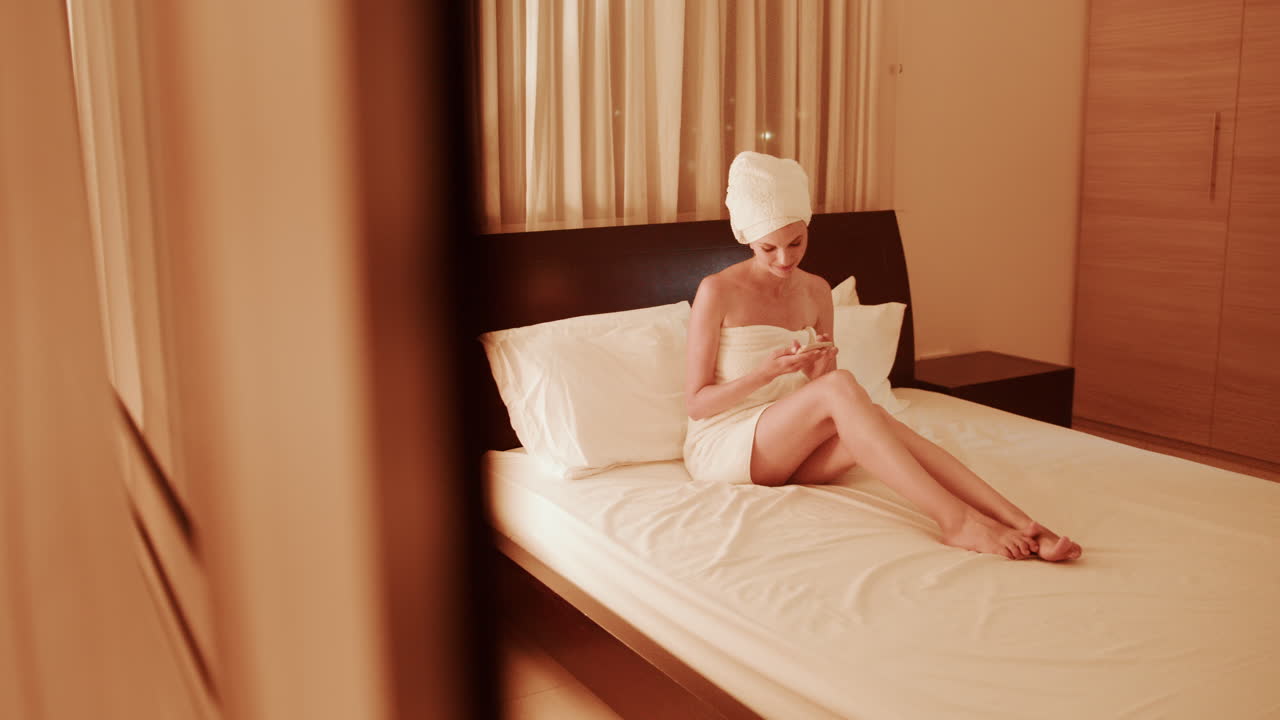 머리에 수건을 고 침대에서 휴식을 취하는 여자