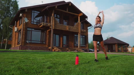 woman on the grass doing yoga on the background of a beautiful house. the concept of a healthy lifestyle