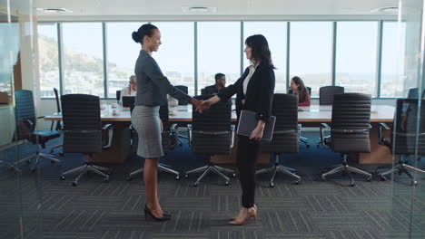 business women handshake in boardroom corporate partnership deal female executives shaking hands welcoming opportunity for cooperation in office 4k