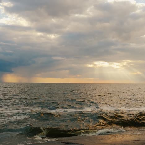 Puesta-De-Sol-Junto-Al-Mar-Donde-Los-Rayos-Del-Sol-Brillan-Desde-Una-Nube-Tormentosa