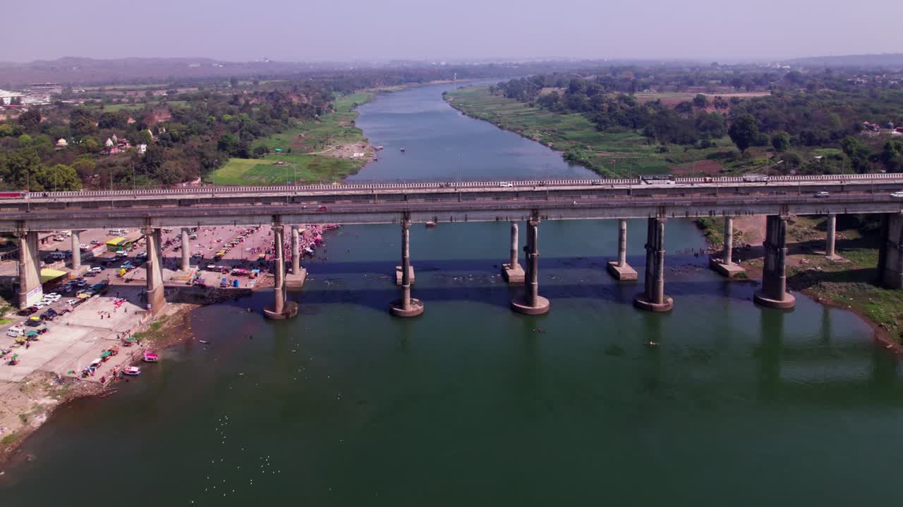 Narmada river with national highway bridge and greenery at Tilwara ghat, jabalpur, madhya pradesh, india. day time, push back, drone shot, 4k.