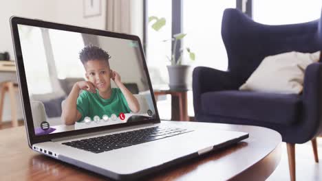 Composition-of-laptop-online-learning-with-african-american-schoolboy-on-screen