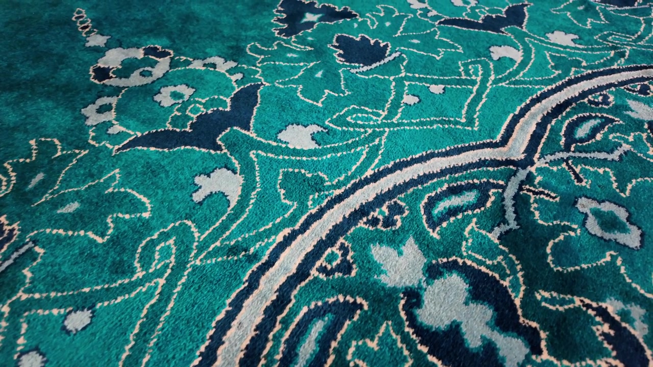 Primo piano di un motivo ornamentale di tappeto verde e blu