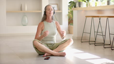 A-mature-Caucasian-woman-with-grey-hair-meditating-on-floor