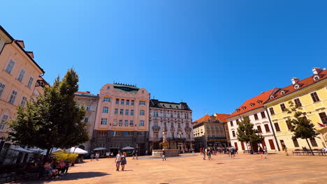 spectacular square with old architecture and beautiful fountain. people walk by the old town in bratislava, slovakia